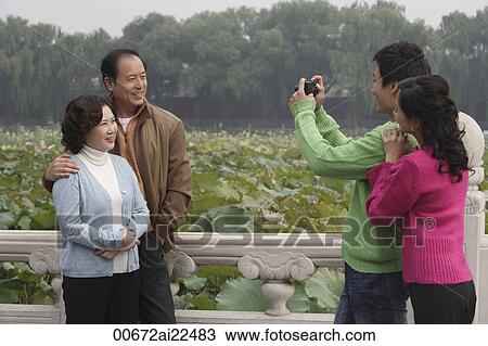 Stock Image - A family pose for photos together while on vacation. Fotosearch