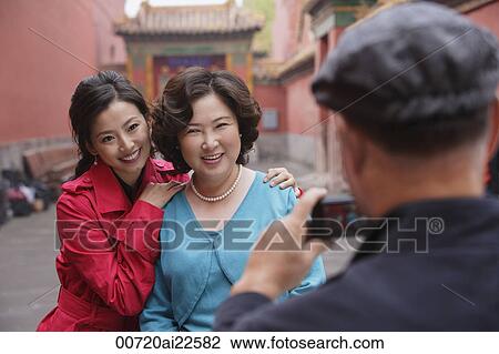 Stock Image - A family pose for photos together while on vacation. Fotosearch