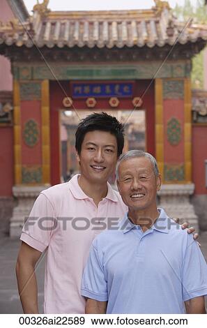 A grandfather and grandson look at the camera as they stand in front of a tourist destination for a photo View Large Photo Image Stock Photo - A grandfather and grandson look at the camera as they stand in front of a tourist destination for a photo. Fotosearch
