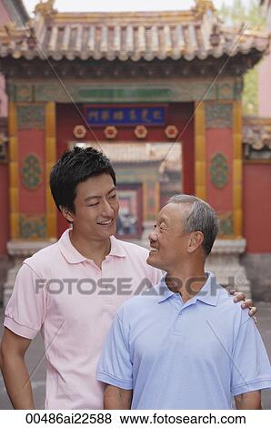 A grandfather and grandson stand in front of a tourist destination for a photo View Large Photo Image Stock Photo - A grandfather and grandson stand in front of a tourist destination for a photo. Fotosearch