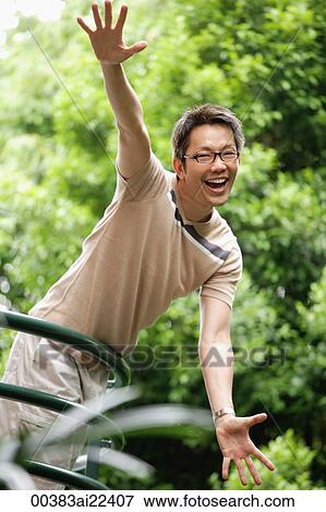 A man is excited as he leans out over a railing View Large Photo Image Stock Photo - A man is excited as he leans out over a railing. Fotosearch