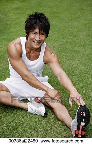 A man looks at the camera as he stretches in the park View Large Photo Image Stock Image - A man looks at the camera as he stretches in the park. Fotosearch