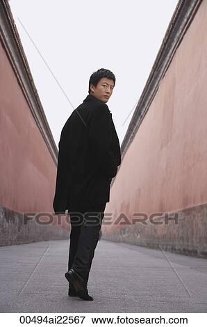 A man looks back at the camera as he walks away View Large Photo Image Stock Photo - A man looks back at the camera as he walks away. Fotosearch