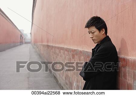 A man looks sad as he leans against a wall View Large Photo Image Stock Photo - A man looks sad as he leans against a wall. Fotosearch