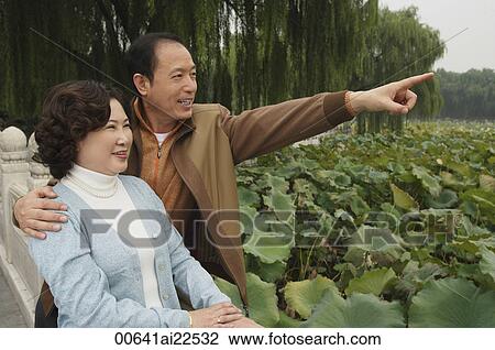 A man points out something in the distance to his wife View Large Photo Image Stock Image - A man points out something in the distance to his wife. Fotosearch