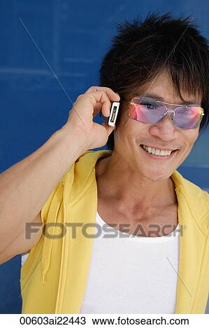 A man smiles as he uses his cellphone View Large Photo Image Stock Image - A man smiles as he uses his cellphone. Fotosearch