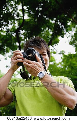 Stock Photograph - A man takes photos outdoors. Fotosearch