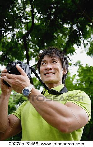 Stock Photography - A man takes photos outdoors. Fotosearch