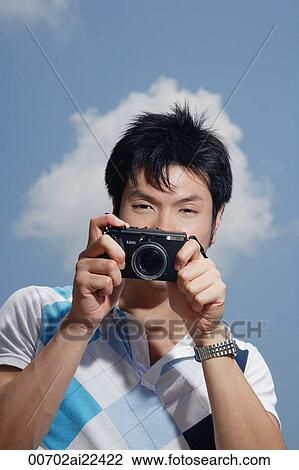 Stock Image - A man takes photos. Fotosearch