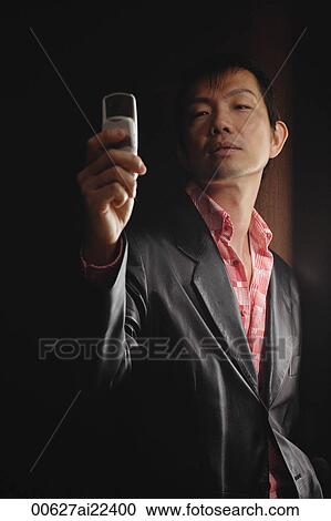 Stock Image - A stylish man looks at his cellphone. Fotosearch