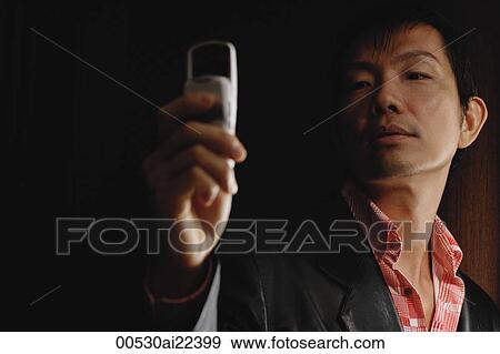 Stock Photo - A stylish man looks at his cellphone. Fotosearch