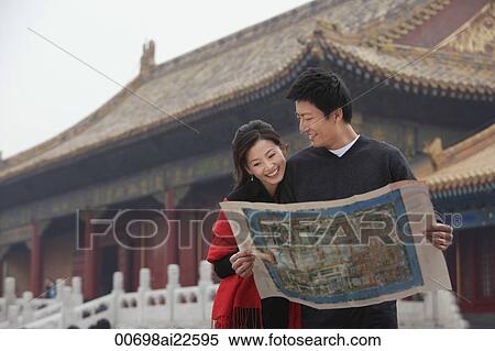 Stock Photography - A tourist couple look at a map together in front of The Forbidden City, Beijing. Fotosearch