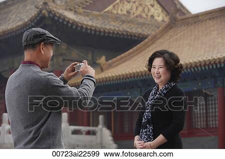 A woman smiles as she has her photo in front of The Forbidden City, Beijing View Large Photo Image Stock Photo - A woman smiles as she has her photo in front of The Forbidden City, Beijing. Fotosearch