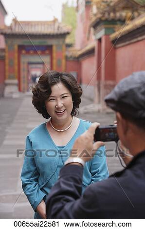 Stock Image - A woman smiles as she has her photo taken while on vacation. Fotosearch