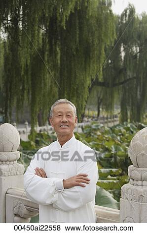 An old man crosses his arms as he looks at the camera View Large Photo Image Stock Photo - An old man crosses his arms as he looks at the camera. Fotosearch