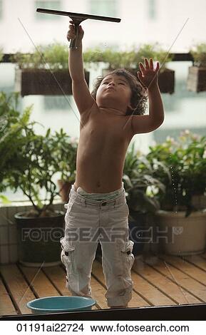 Picture - Baby boy cleaning the window. Fotosearch