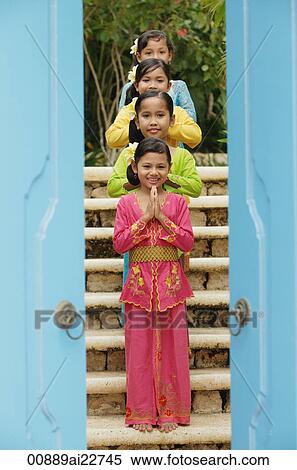 Stock Photography - Balinese girls standing in row, looking at camera. Fotosearch