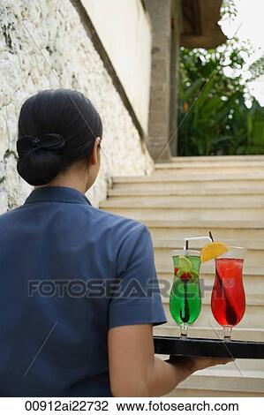Balinese waitress carrying cocktails View Large Photo Image Stock Image - Balinese waitress carrying cocktails. Fotosearch