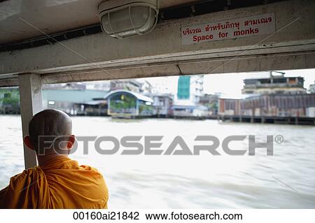 Stock Image - Buddhist monk on river boat taxi, Chao Praya River, Thailand. Fotosearch