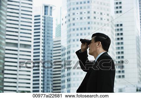 Stock Image - Businessman looking through binoculars. Fotosearch