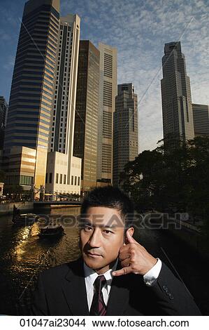 Picture - Businessman making a phone gesture. Fotosearch