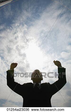 Stock Photograph - Businessman raising arms in victory. Fotosearch