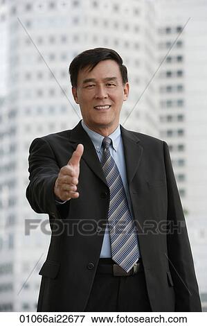 Stock Photo - Businessman reaching out hand for handshake. Fotosearch
