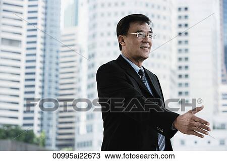 Businessman reaching out his hand for handshake View Large Photo Image Stock Image - Businessman reaching out his hand for handshake. Fotosearch