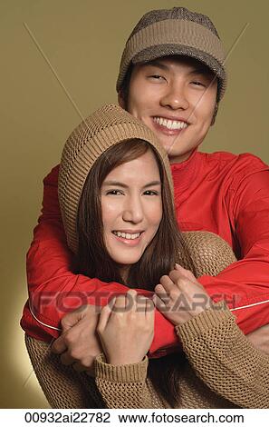 Stock Image - Couple hugging and smiling at camera. Fotosearch