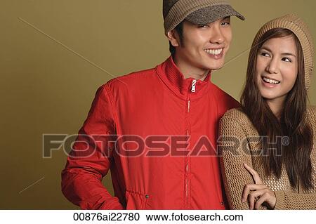 Stock Image - Couple leaning against one another and smiling. Fotosearch