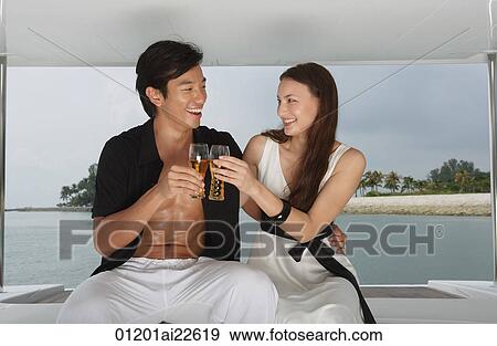 Couple on yacht, toasting with glasses View Large Photo Image Stock Photo - Couple on yacht, toasting with glasses. Fotosearch