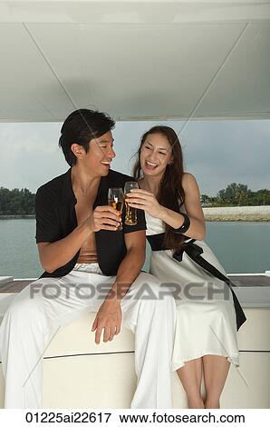 Couple on yacht, toasting with glasses View Large Photo Image Stock Photo - Couple on yacht, toasting with glasses. Fotosearch