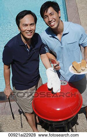 Stock Photo - Father and son enjoying barbeque. Fotosearch