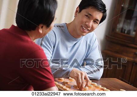 Stock Photo - Father and son playing board game. Fotosearch