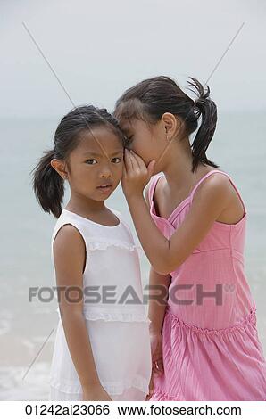 Girl whispering into sister's ear View Large Photo Image Stock Photograph - Girl whispering into sister's ear. Fotosearch