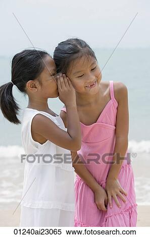 Girl whispering into sister's ear View Large Photo Image Stock Photography - Girl whispering into sister's ear. Fotosearch