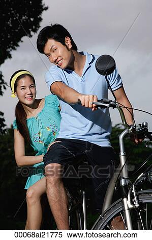 Man and woman on bike, looking at camera View Large Photo Image Stock Photography - Man and woman on bike, looking at camera. Fotosearch