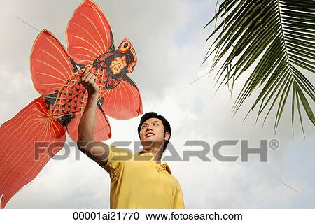 Stock Image - Man flying Chinese kite. Fotosearch