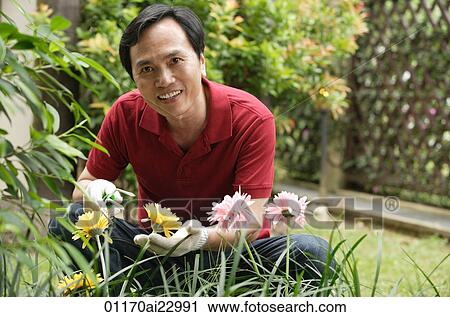 Stock Image - Man gardening and smiling at camera. Fotosearch