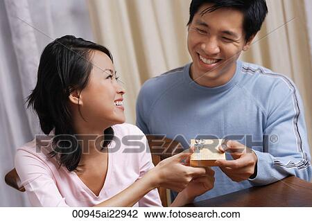Man giving woman a small present View Large Photo Image Stock Image - Man giving woman a small present. Fotosearch