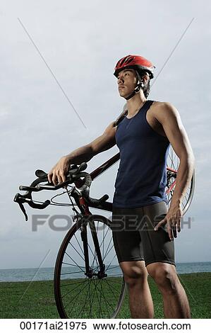 Man holding bike along ocean, wearing helmet, workout View Large Photo Image Stock Photography - Man holding bike along ocean, wearing helmet, workout. Fotosearch