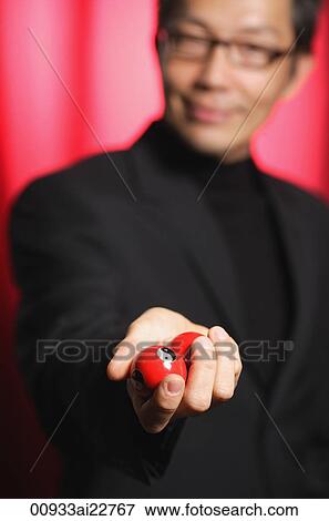 Stock Photo - Man holding Chinese medicine balls, looking at camera. Fotosearch