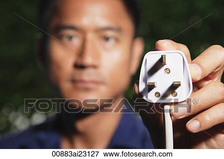 Man holding plug at camera View Large Photo Image Stock Photo - Man holding plug at camera. Fotosearch