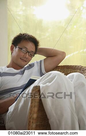 Man in chair, reading a book View Large Photo Image Stock Image - Man in chair, reading a book. Fotosearch