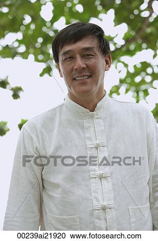 Stock Image - Man in park, smiling at camera. Fotosearch