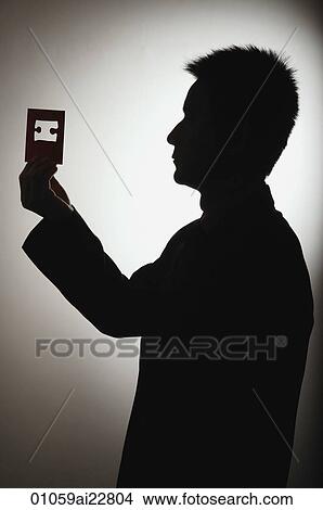 Man looking through puzzle piece cutout View Large Photo Image Picture - Man looking through puzzle piece cutout. Fotosearch