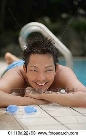 Man lying next to pool, smiling at camera View Large Photo Image Stock Image - Man lying next to pool, smiling at camera. Fotosearch