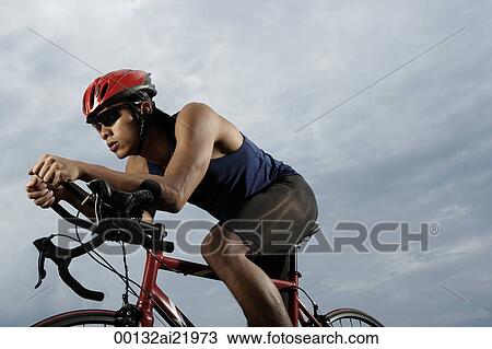 Man on bike racing, workout, wearing helmet View Large Photo Image Stock Image - Man on bike racing, workout, wearing helmet. Fotosearch