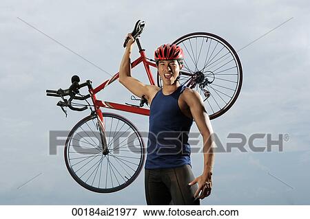 Man raising bike over shoulders, happy, finished race, looking at camera View Large Photo Image Stock Photo - Man raising bike over shoulders, happy, finished race, looking at camera. Fotosearch