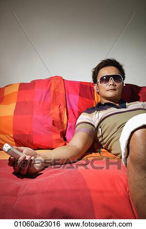 Stock Photograph - Man relaxing on bed. Fotosearch